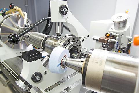 Eine Hochpräziszionsschleifmaschine bei der Arbeit: Das Werkstück aus Metall wird nach Kundenwunsch bearbeitet.   Foto: Overbeck