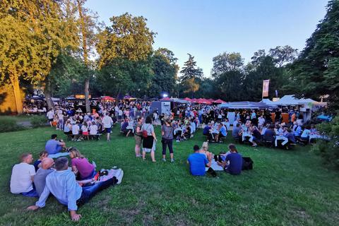 Am Tisch oder auf Picknickdecken machen es sich die Besucher des fünften Rüsselsheimer Weinfestes im Verna-Park gemütlich. Foto: Michaela Kabon