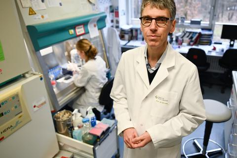Professor Stephan Becker (r), Direktor des Instituts für Virologie der Philipps-Universität Marburg, steht in einem Forschungslabor neben einer Sterilwerkbank.  Foto: dpa