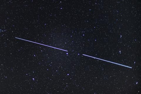 Zwei "Starlink"-Satelliten sind als Lichtstreifen am Nachthimmel zu sehen. Foto: dpa