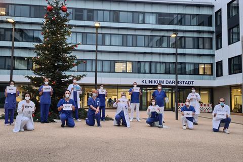 Mitarbeiter des Klinikum Darmstadt mit ihrer Weihnachtsbotschaft: „Bleiben Sie zu Hause, wir bleiben für Sie im Dienst“.  Foto: Klinikum Darmstadt