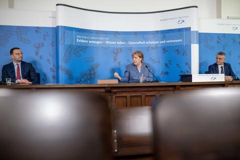 Kanzlerin Angela Merkel (mitte) spricht bei einer Pressekonferenz nach ihrem Besuch im Robert Koch-Institut (RKI) neben Gesundheitsminister Jens Spahn (links) und Lothar Wieler, Präsident des Robert Koch-Instituts (rechts). Foto: dpa