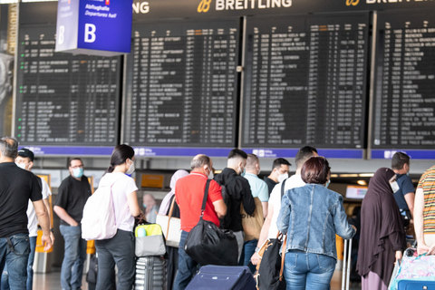 Passagiere warten in der Schalterhalle des Frankfurter Flughafens. Foto: Boris Roessler/dpa