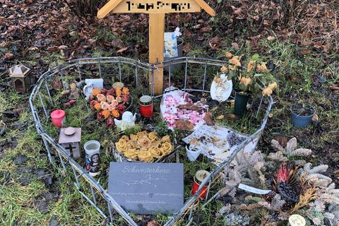 Ein Holzkreuz, Blumen, Fotos und Kerzen erinnern an der Fundstelle an die von ihrem Mann getötete Biebesheimerin. Foto: Marion Menrath
