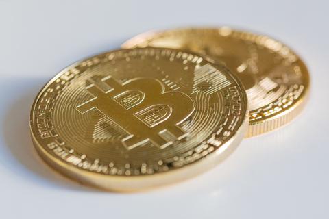 Zwei Bitcoin-Münzen liegen auf einem Tisch. Bitcoins sind eine sogenannte Kryptowährung.  Foto: dpa