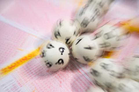Lottokugeln liegen auf einem Lottoschein. Symbolfoto: dpa