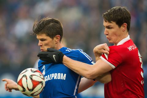 Schalkes Stürmer Klaas-Jan Huntelaar (l) und 05-Abwehrspieler Philipp Wollscheid im Zweikampf. Foto: dpa