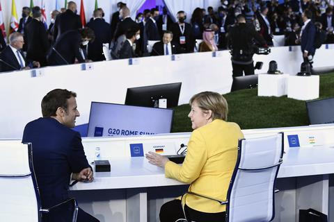Emmanuel Macron, Präsident von Frankreich, unterhält sich mit Angela Merkel (CDU), der geschäftsführenden Bundeskanzlerin von Deutschland, vor der Eröffnungssitzung des G20-Gipfels im Konferenzzentrum La Nuvola. Der zweitägige Gipfel der Gruppe der 20 ist das erste persönliche Treffen der Staats- und Regierungschefs der größten Volkswirtschaften der Welt seit Beginn der Corona-Pandemie. Foto: dpa