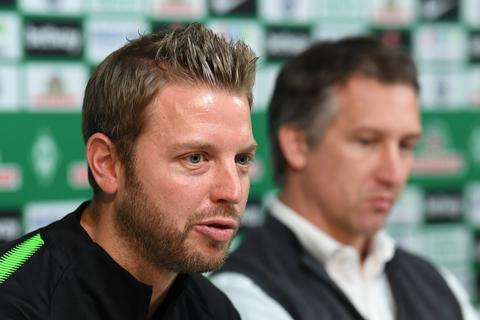 Werder Bremens Interimstrainer Florian Kohfeldt (links) und Werder Bremens Geschäftsführer Sport, Frank Baumann, sitzen bei einer Pressekonferenz zusammen. Foto: dpa