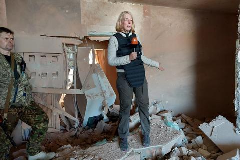 Katrin Eigendorf in schusssicherer Weste bei ihrer Arbeit: Sie steht in der Ukraine in Trümmern einer zerbombten Wohnung. Eigendorf informiert die Zuschauer vom Ort des Geschehens in Live-Schalten, Beiträgen und Dokumentationen. Foto: Katrin Eigendorf/ZDF