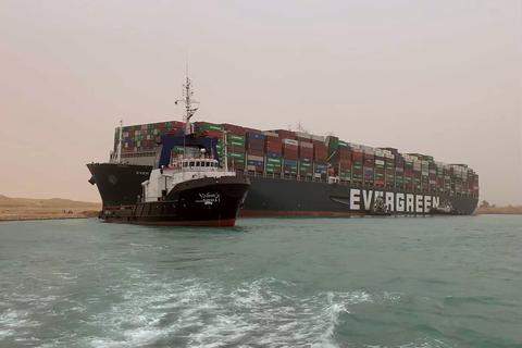 Ein Schlepper zieht das Frachtschiff mit der Aufschrift "Ever Green" im Suezkanal. Das Schiff ist in der Nacht zum 24. März auf Grund gelaufen und blockierte seither die wichtige Schifffahrtsstraße zwischen Asien und Europa.  Foto: Uncredited/Suez Canal Authority/AP/dpa