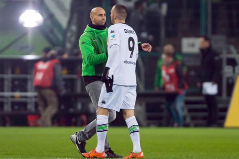 Gladbachs Cheftrainer Andre Schubert gibt nach der deutlichen Niederlage gegen Borussia Dortmund seinem Stürmer Josip Drmic die Hand. Foto: dpa 