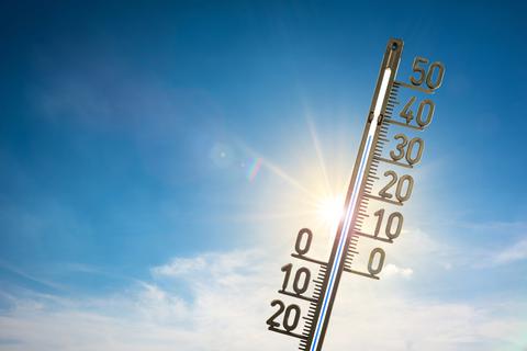 Ein Thermometer zeigt 36 Grad vor blauem Himmel und strahlender Sonne.