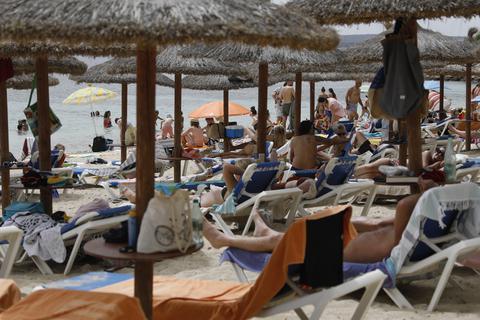 Touristen entspannen an einem Strand bei Puerto Portals auf Mallorca auf Strandliegen. Spanien ist von Covid-19 erneut stark betroffen und wird von deutschen Behörden weiter als Hochrisikogebiet eingestuft. Foto: dpa