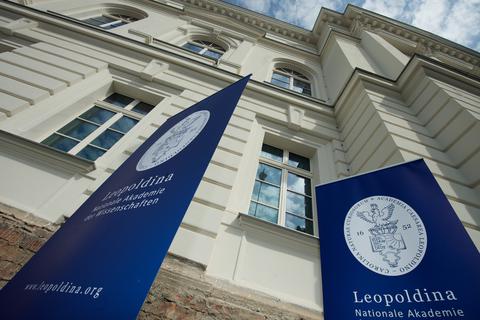 Das Logo und der Schriftzug der Nationalen Akademie der Wissenschaften Leopoldina hängen an einem Banner vor dem Gebäude.  Archivfoto: Peter Endig/dpa-Zentralbild/dpa