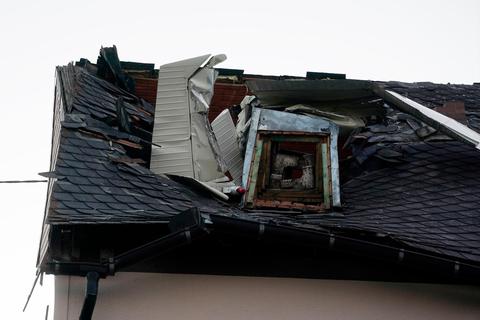 Wrackteile eines Kleinflugzeuges ragen aus dem Dach eines Wohnhauses. Foto: Thomas Frey/dpa 