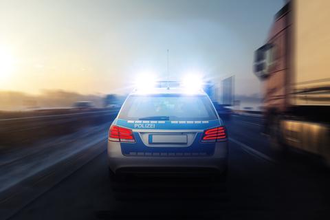 Ein Polizeiauto fährt auf der Autobahn zu einem Einsatz.