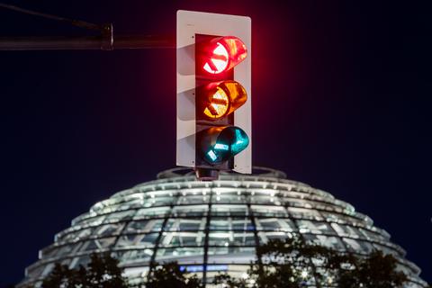 Eine Ampel vor der Kuppel des Reichstagsgebäudes in Berlin leuchtet in einer Langzeitbelichtung in allen drei Phasen. Foto: dpa