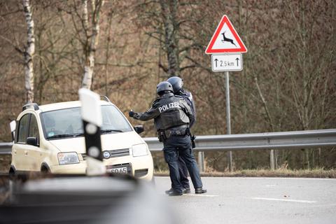 Polizeibeamte kontrollieren an einer Absperrung an der Kreisstraße 22 ein Auto. Einen Kilometer entfernt waren zwei Polizisten erschossen worden.  Foto: Sebastian Gollnow/dpa