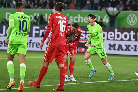 Ein Freitagabend zum Vergessen: Der Wolfsburger Jonas Wind (rechts) freut sich über einen seiner zwei Treffer, was den 05er Anton Stach (Mitte) wenig begeistert. Foto: dpa