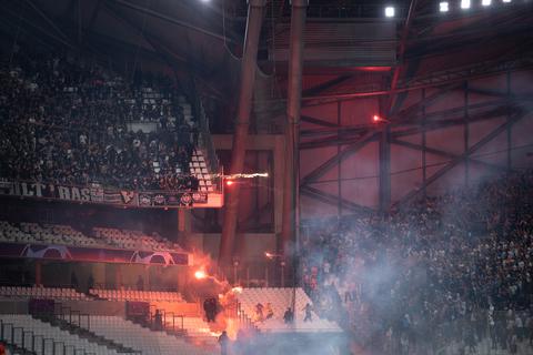 Die Blöcke der Ultras der Eintracht (l) und von Marseille beschießen sich mit Feuerwerk.  Foto: Sebastian Gollnow/dpa