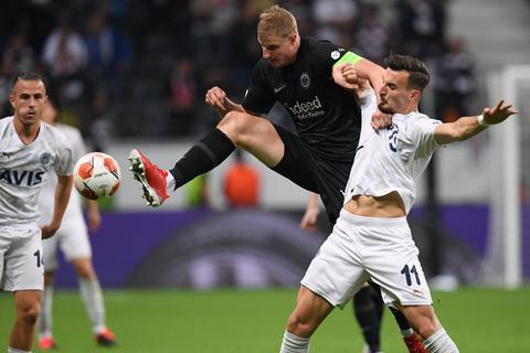 Martin Hinteregger (M) und Istanbuls Mergim Berisha kämpfen im Europa-League-Spiel um den Ball.  Foto: dpa