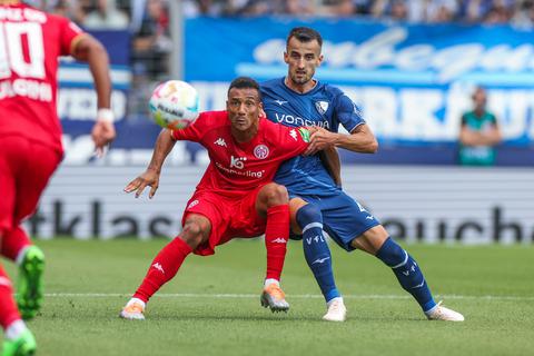 Karim Onisiwo (l) von Mainz 05 erwartet mit Erhan Masovic vom VfL Bochum den Ball. Foto: dpa