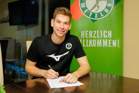 Lukas Becher beim Unterschreiben seines neuen Vertrags bei der HSG Wetzlar. Foto: Verein 
