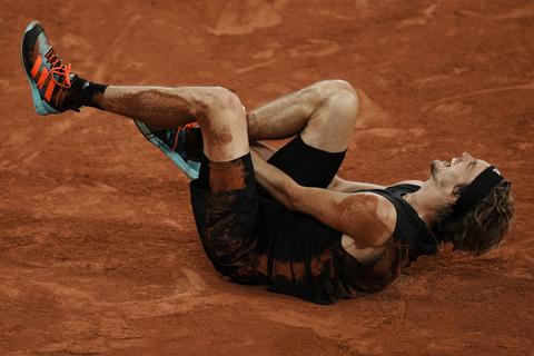 Alexander Zverev verrenkt sich vor Schmerzen, nachdem er sich während des Spiels den rechten Knöchel verdreht hat.  Foto: Thibault Camus/AP/dpa