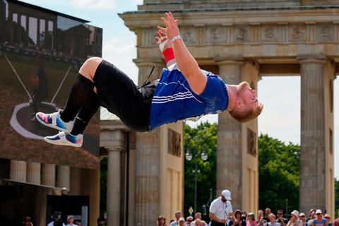 Kugelstoßer Simon Bayer bejubelte mit einem Salto seinen zweiten Platz im Kugelstoßen am Brandenburger Tor. Foto: dpa 